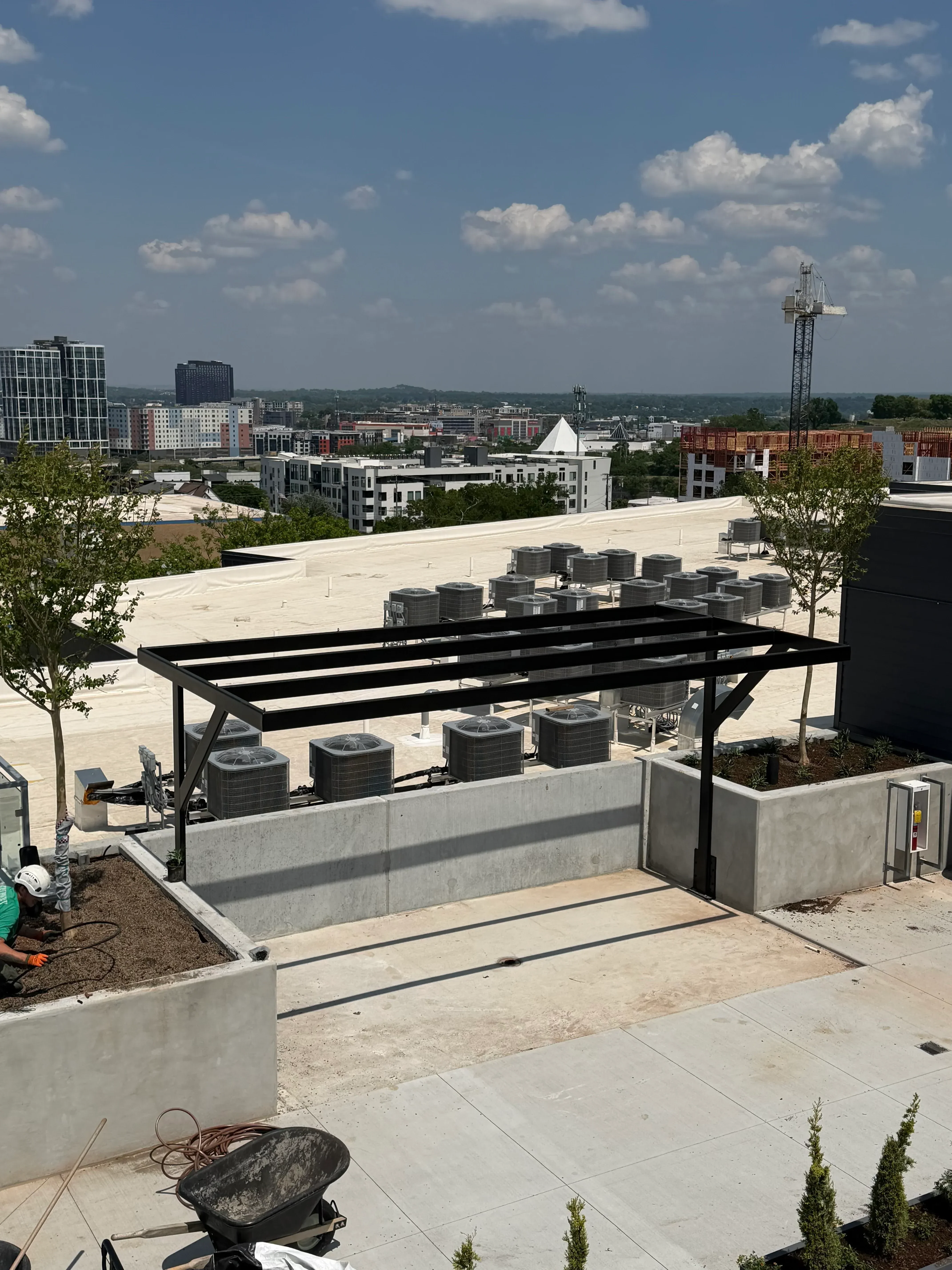 Black steel railing with welded frame on commercial rooftop concrete deck