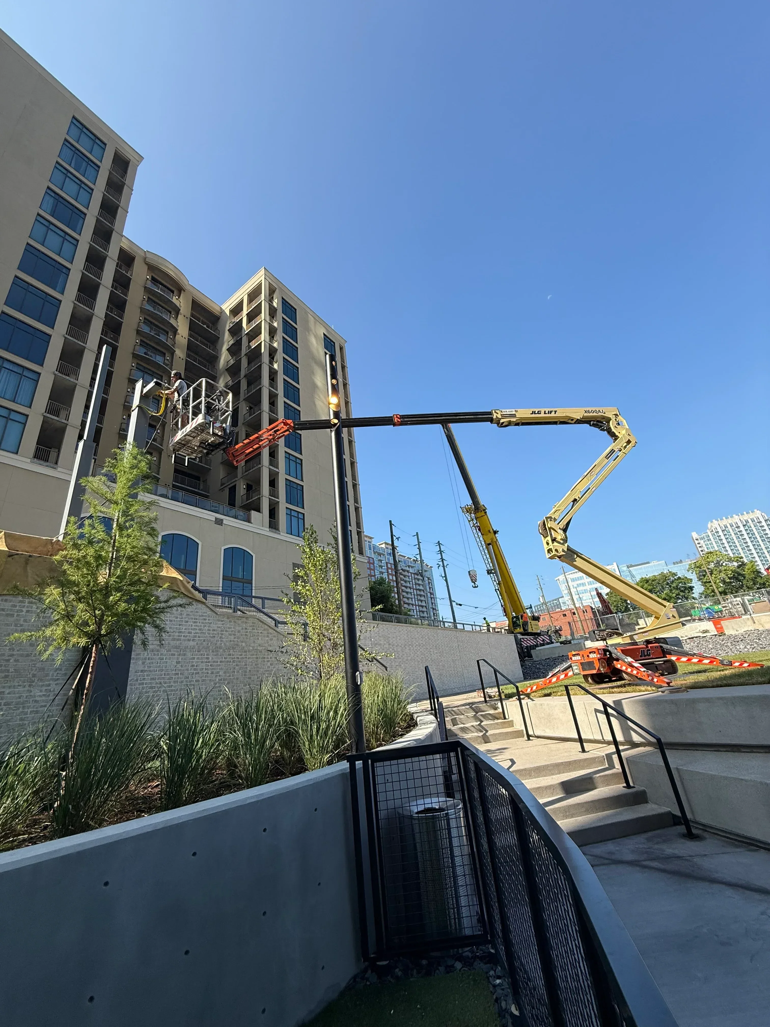 Yellow articulating concrete pump boom with welded steel frame mounted on multi-story building