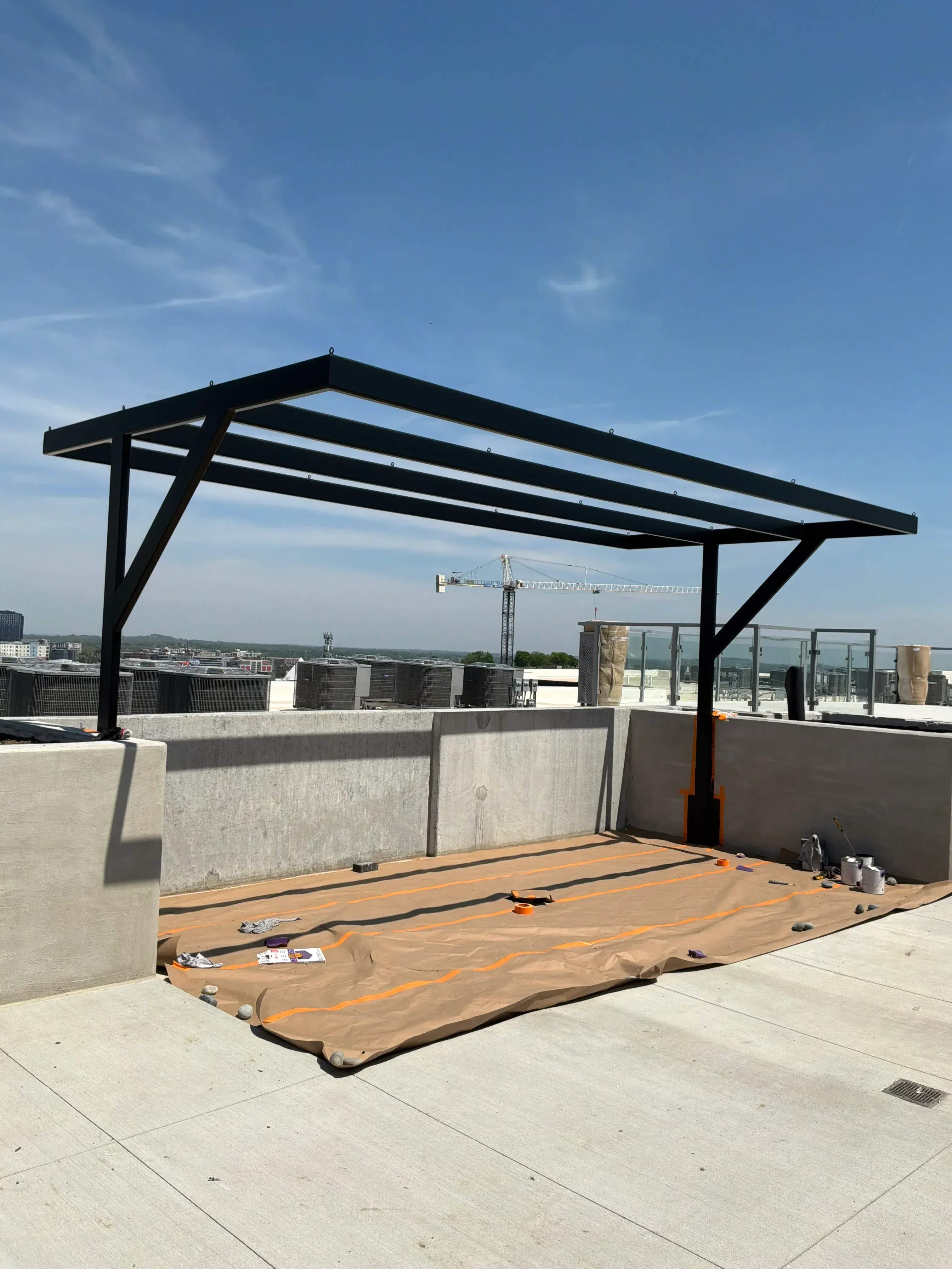 Black steel structural frame with diagonal bracing supporting exterior platform and staircase installation