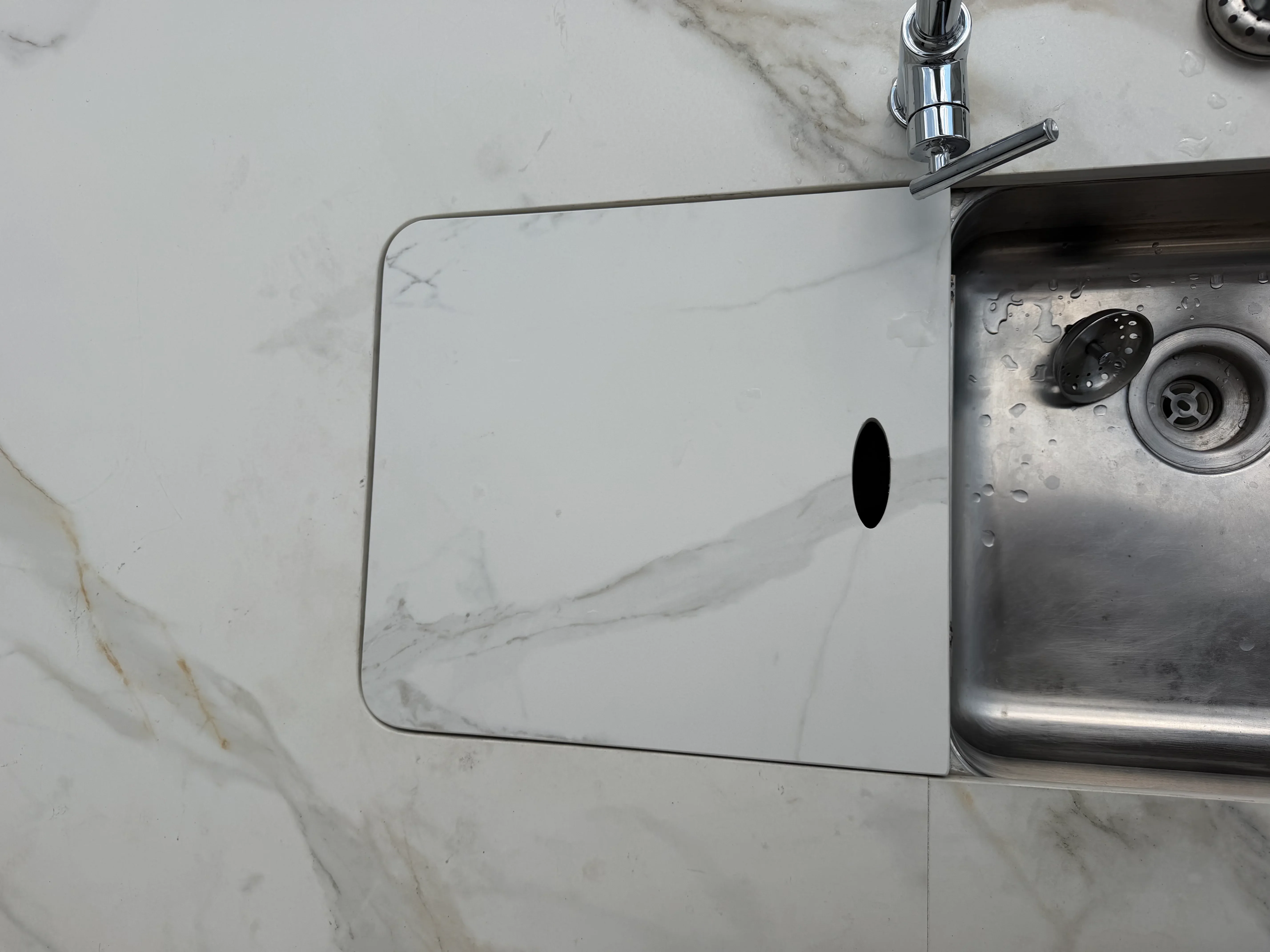 Stainless steel undermount sink with chrome faucet installed in marble countertop