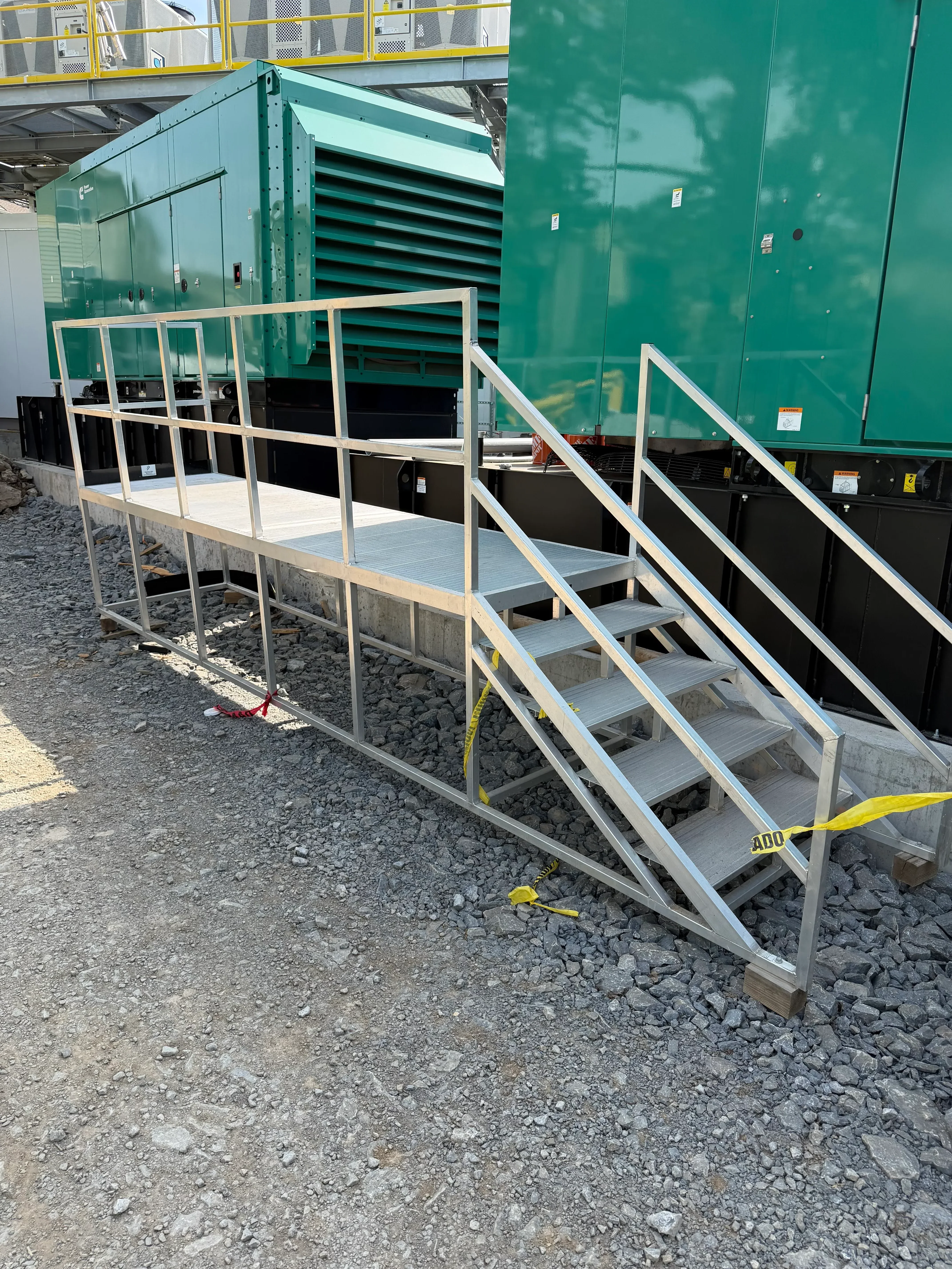 Welded steel stairway with handrails and safety railings attached to industrial container