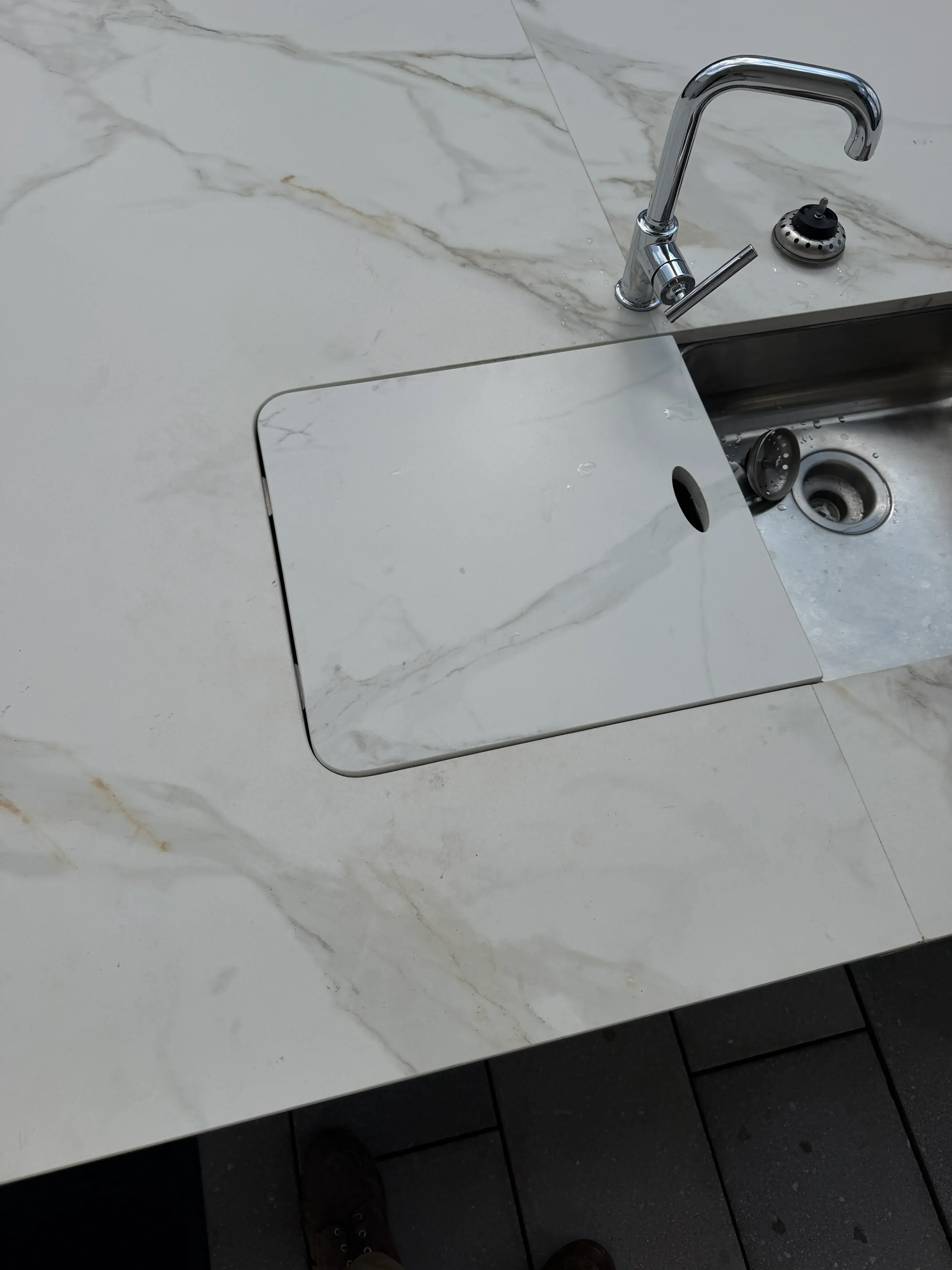 Chrome shower door frame and grab bar on marble tile wall with recessed soap niche