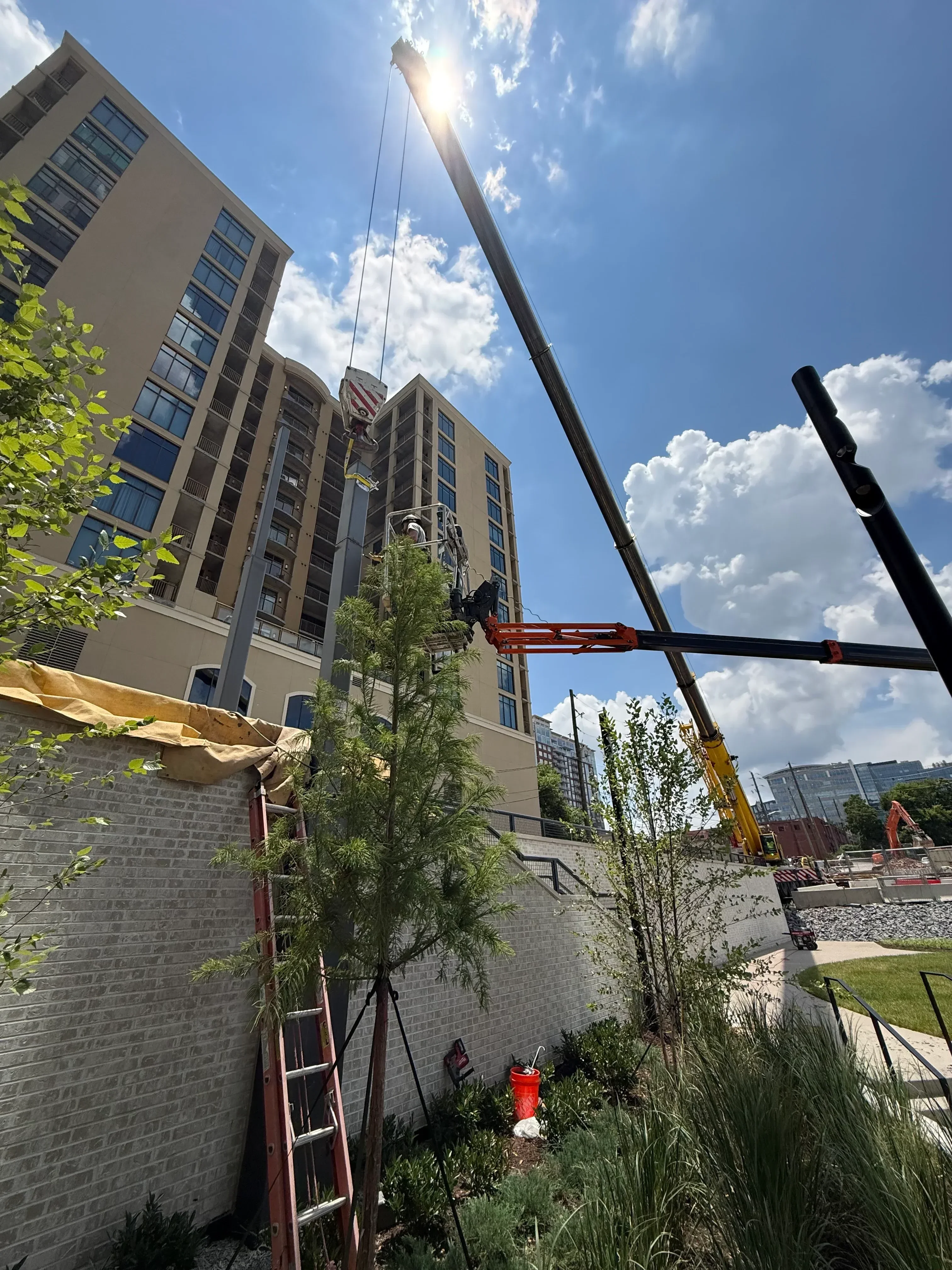 Black steel I-beams and red support columns installed on multi-story commercial building facade