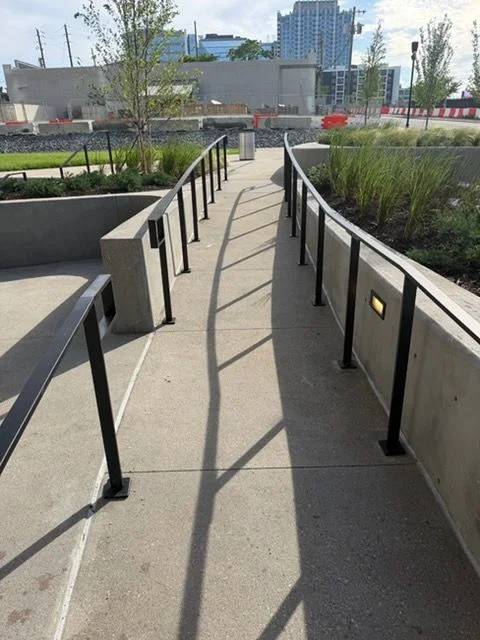 Custom fabricated metal commercial railings installed along an interior staircase in a Nashville, Tennessee office building. Steel guardrails run the full length of the stairway with clean welds and a dark powder-coated finish.