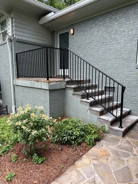 A repaired exterior metal staircase on a residential property in Nashville, Tennessee, showing solid treads, secure railings, and clean welds after professional repair work. The staircase is free of visible rust and structural damage.